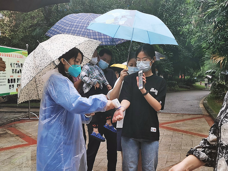 5..自愿者蔡玉琴雨中举行扫康健码事情.jpg